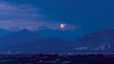 Photo by Partially Eclipsed Moon Rising Above Geneva and The Alps